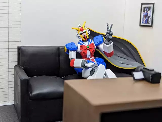 camera casting_couch couch funny g_gundam gundam gunpla gunplagonewild indoors mecha mecha_musume mobile_doll nobel_gundam tagme tagme_(artist) v victory_pose victory_sign video_camera